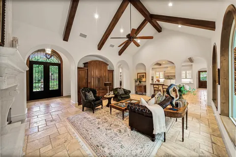 a living room with furniture a fireplace and a chandelier