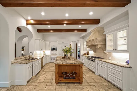 a large kitchen with kitchen island a sink a counter top space and living room view