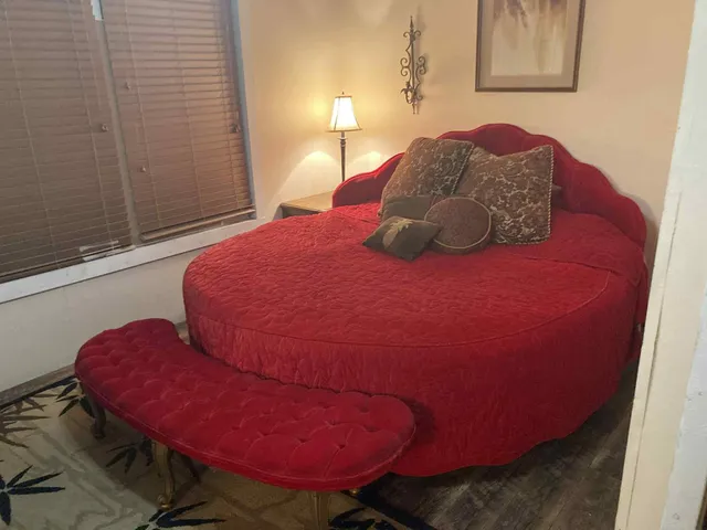 a bed sitting in a bedroom next to a window