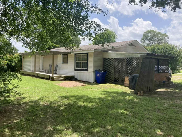 a view of a house with backyard and a tree