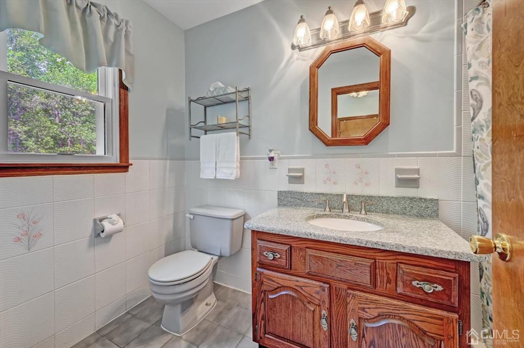 38 Pittenger Pond Road Freehold, NJ 07728 - Photo 27 of 43 a bathroom with a granite countertop toilet a sink and a mirror