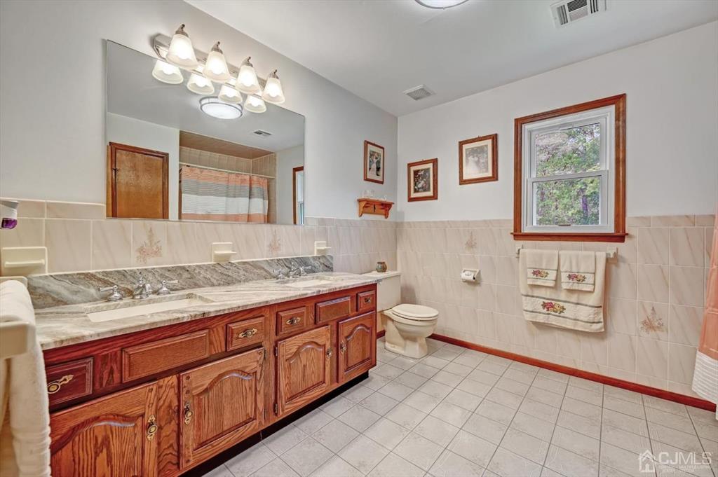 38 Pittenger Pond Road Freehold, NJ 07728 - Photo 32 of 43 a spacious bathroom with a granite countertop toilet sink and mirror