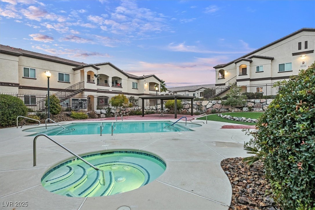 2291 West Horizon Ridge Parkway, Unit 1206 Henderson, NV 89052 - Photo 21 of 29 Pool at dusk featuring a community hot tub, a patio area, and a community pool