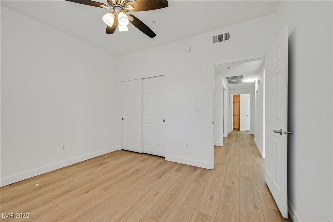 2291 West Horizon Ridge Parkway, Unit 1206 Henderson, NV 89052 - Photo 7 of 29 Unfurnished bedroom with light wood finished floors, ceiling fan, and a closet