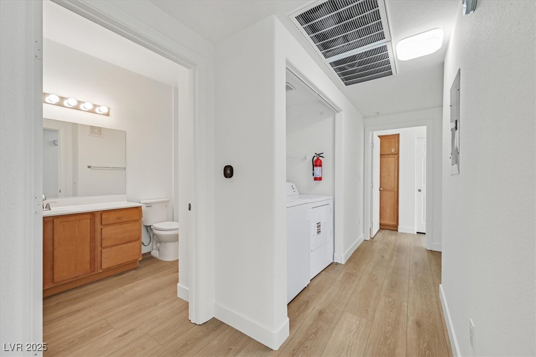 2291 West Horizon Ridge Parkway, Unit 1206 Henderson, NV 89052 - Photo 8 of 29 Hall featuring light wood-style floors and washer / dryer