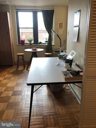 a living room with a table chairs and a window