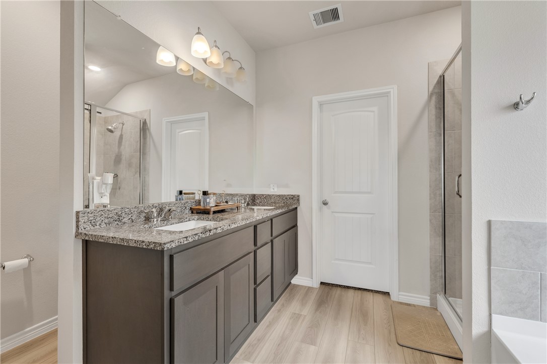 2016 Chief Street Bryan, TX 77807 - Photo 19 of 30 a bathroom with a granite countertop sink a light fixture and a mirror