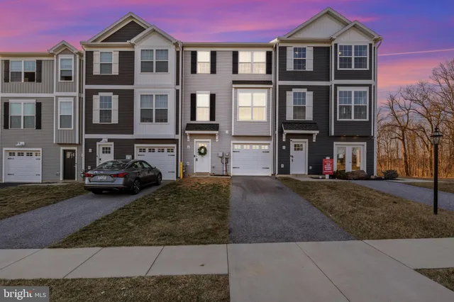 a front view of a residential apartment building with a yard