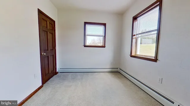 an empty room with windows and closet