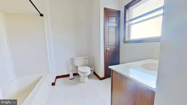 a bathroom with a sink a toilet and a window
