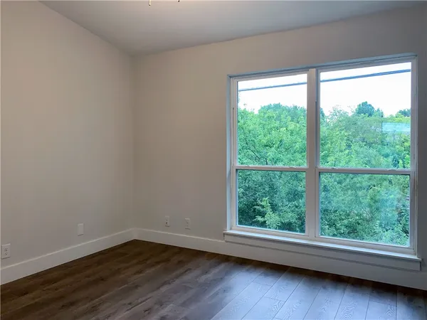 a view of a hallway with wooden floor and bedroom