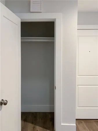 a view of a hallway with wooden floor and a living room