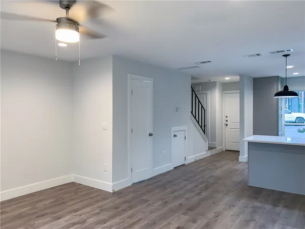a view of a hallway with wooden floor and a chandelier