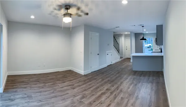 a view of a kitchen with wooden floor and a ceiling fan