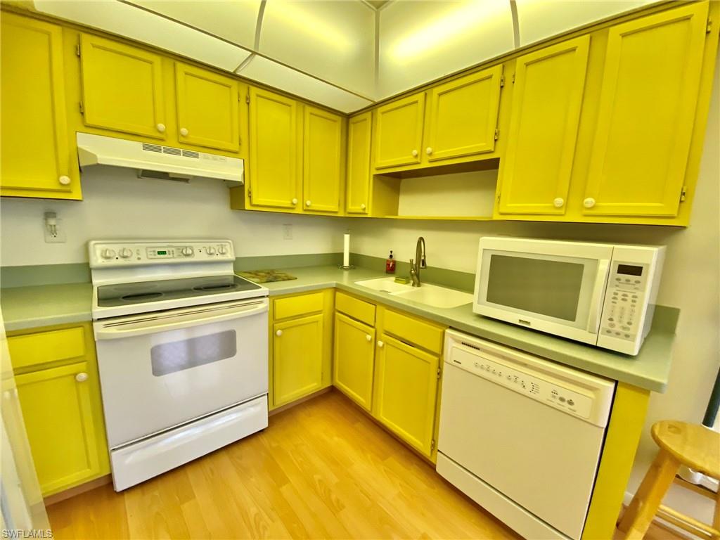 1516 Mainsail Drive, Unit 2 Naples, FL 34114 - Photo 12 of 45 a kitchen with stainless steel appliances granite countertop sink stove and cabinets