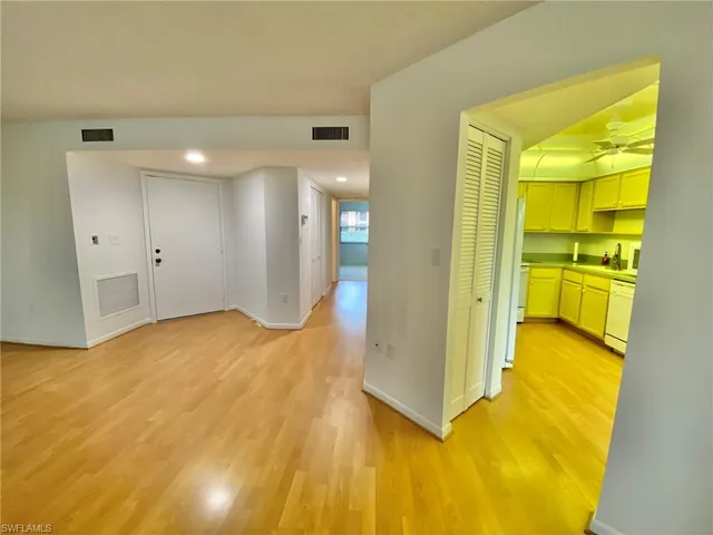 a view of a big room with wooden floor and windows
