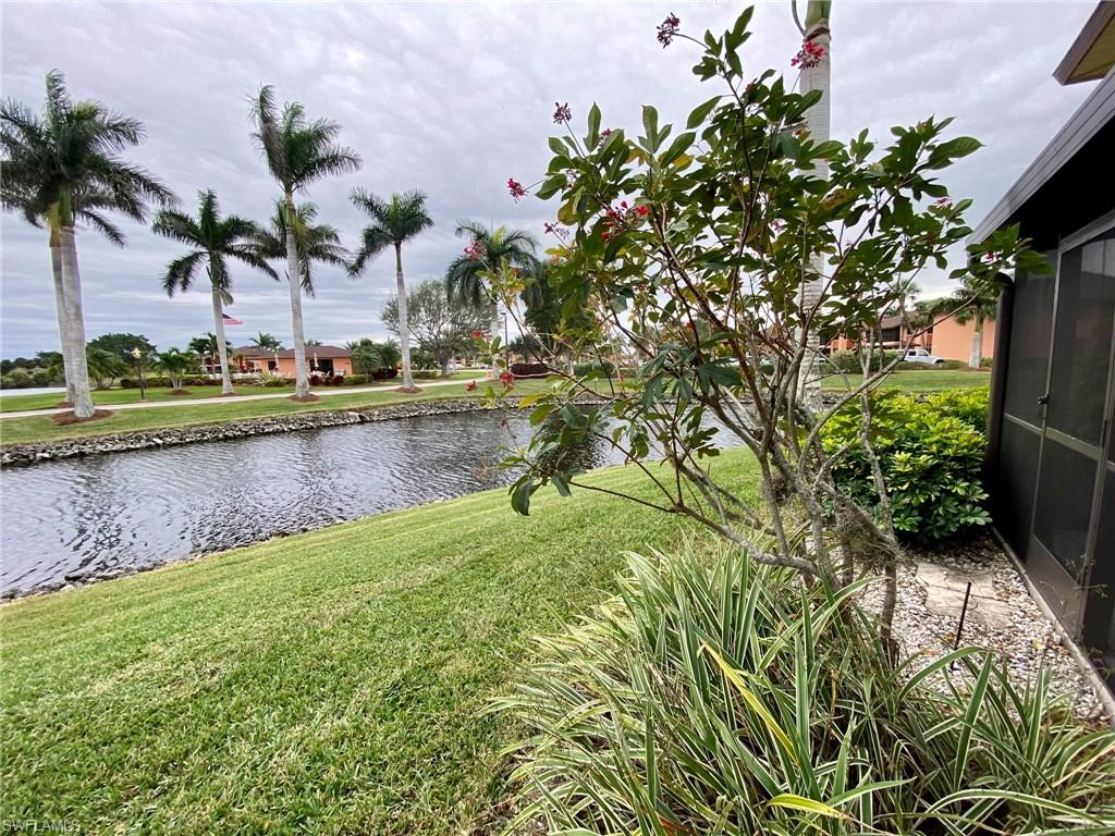 1516 Mainsail Drive, Unit 2 Naples, FL 34114 - Photo 35 of 45 a view of a garden with a bench and trees