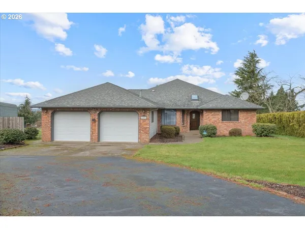 a front view of a house with a garden and yard