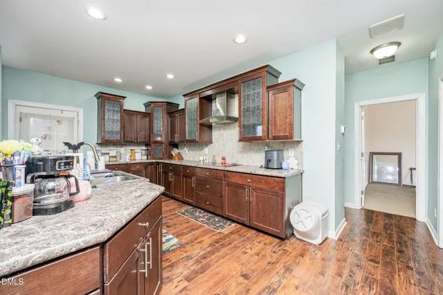 a kitchen with stainless steel appliances granite countertop a sink refrigerator and cabinets