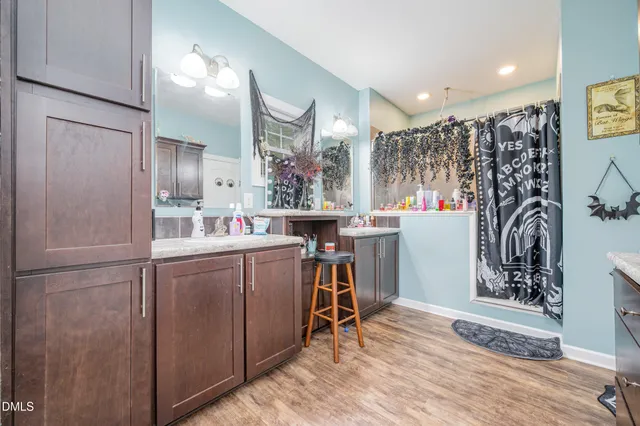 a room with kitchen island a wooden floor and a refrigerator