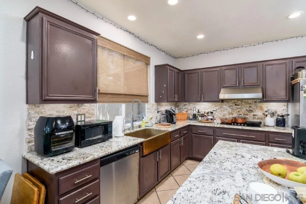 569 Inverlochy Drive Fallbrook, CA 92028 - Photo 14 of 46 a kitchen with a sink stove top oven and cabinets