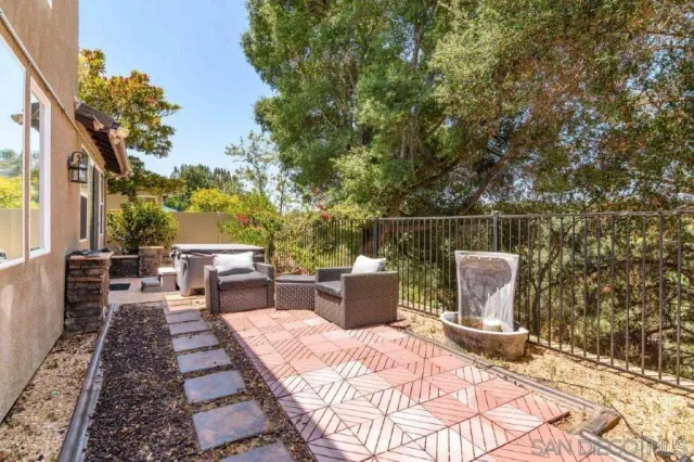 a view of a patio with a dining table and chairs with wooden fence