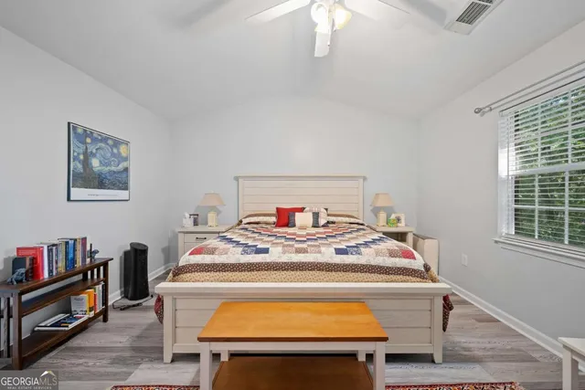 a bedroom with a bed and a dresser next to a window