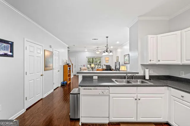 a kitchen with kitchen island granite countertop a sink cabinets and wooden floor
