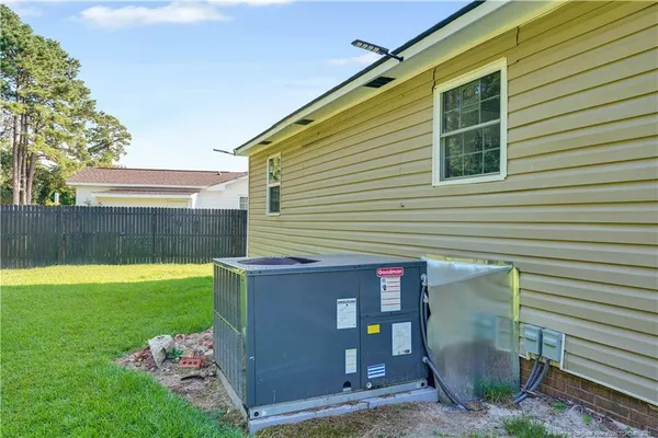 a view of backyard with barbeque grill and wooden fence
