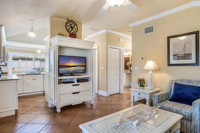 a living room with furniture a flat screen tv and kitchen view