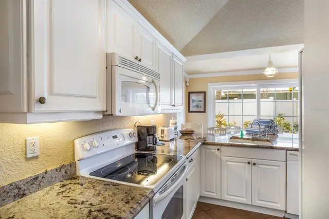 a kitchen with a stove a sink and cabinets