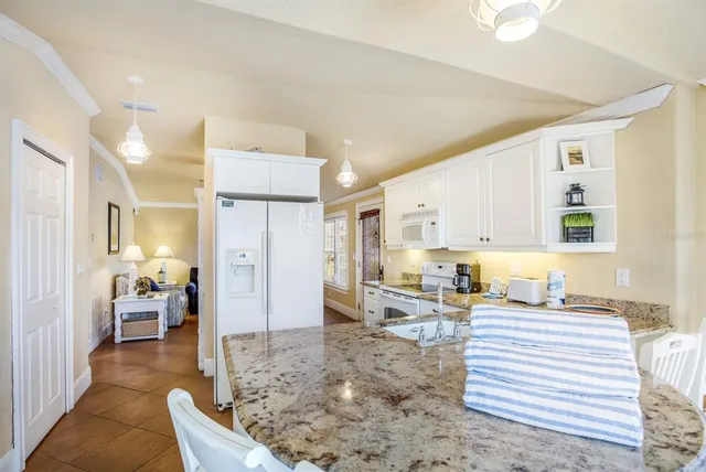 a living room with furniture a rug and kitchen view