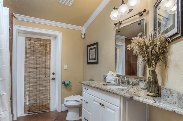 a bathroom with a granite countertop sink toilet and shower
