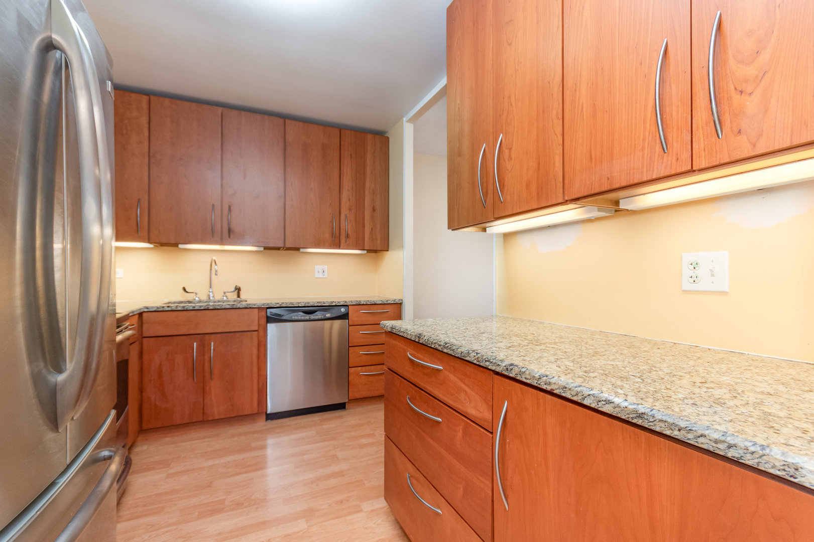 5445 North Sheridan Road, Unit 2306 Chicago, IL 60640 - Photo 13 of 25 a kitchen with stainless steel appliances granite countertop wooden cabinets a refrigerator and dishwasher