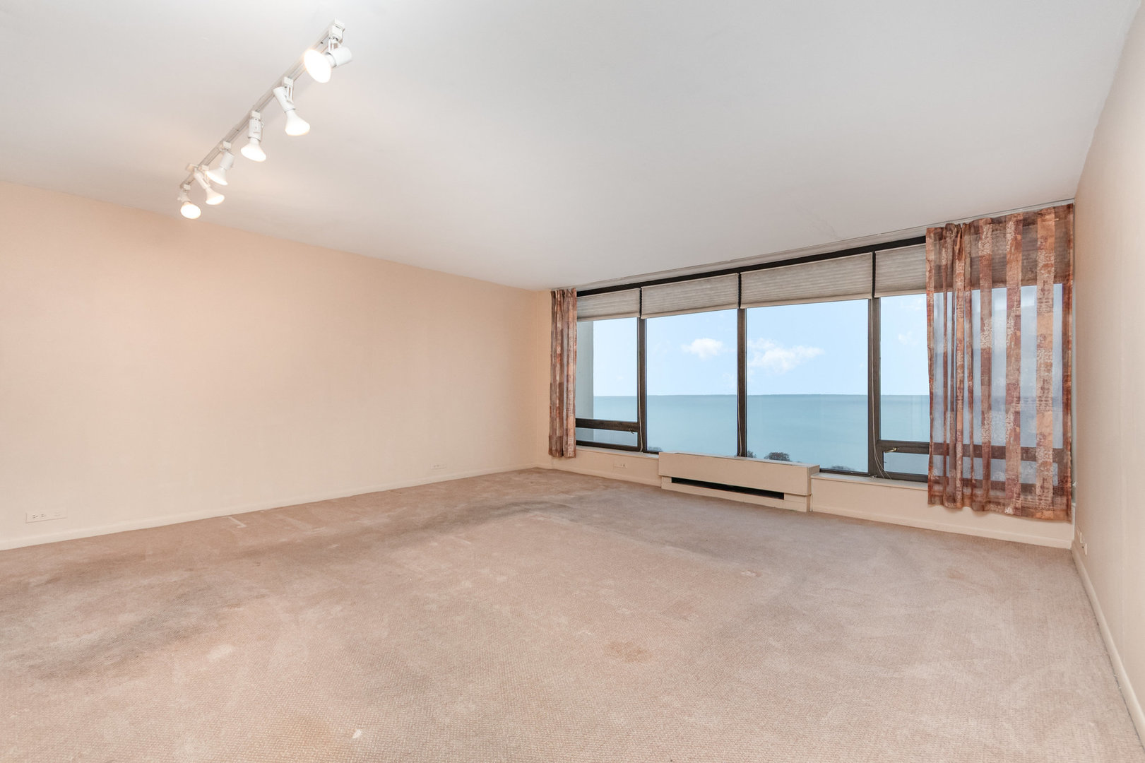 5445 North Sheridan Road, Unit 2306 Chicago, IL 60640 - Photo 7 of 25 an empty room with large windows