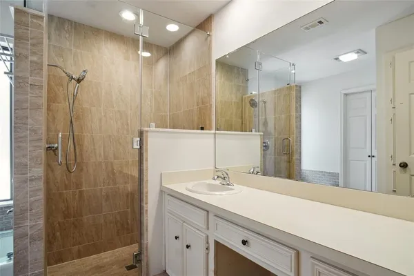 a bathroom with a shower sink and mirror