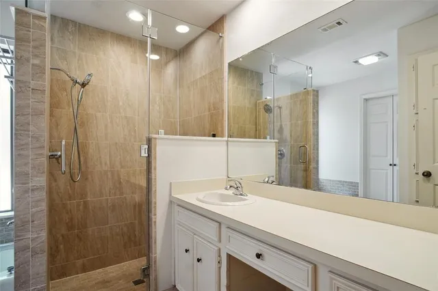 a bathroom with a shower sink and mirror