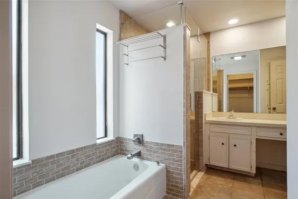 a bathroom with a tub sink and mirror