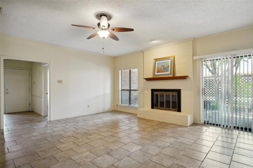 5717 Ridgerock Court Fort Worth, TX 76132 - Photo 5 of 20 a view of a livingroom with a fireplace a ceiling fan and windows