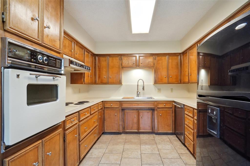 5717 Ridgerock Court Fort Worth, TX 76132 - Photo 6 of 20 a kitchen with a stove sink and cabinets