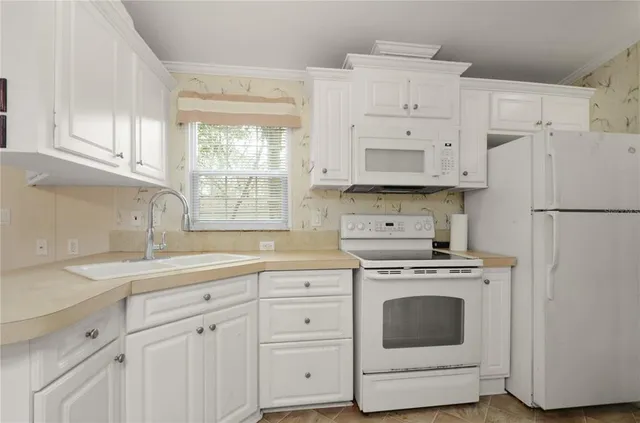 a kitchen with cabinets appliances and a sink