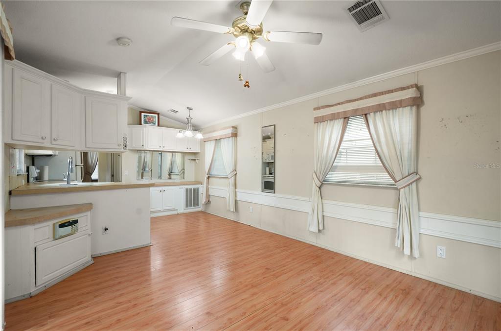 3000 Clarcona Road, Unit 1218 Apopka, FL 32703 - Photo 4 of 22 a kitchen with wooden floors and white cabinets