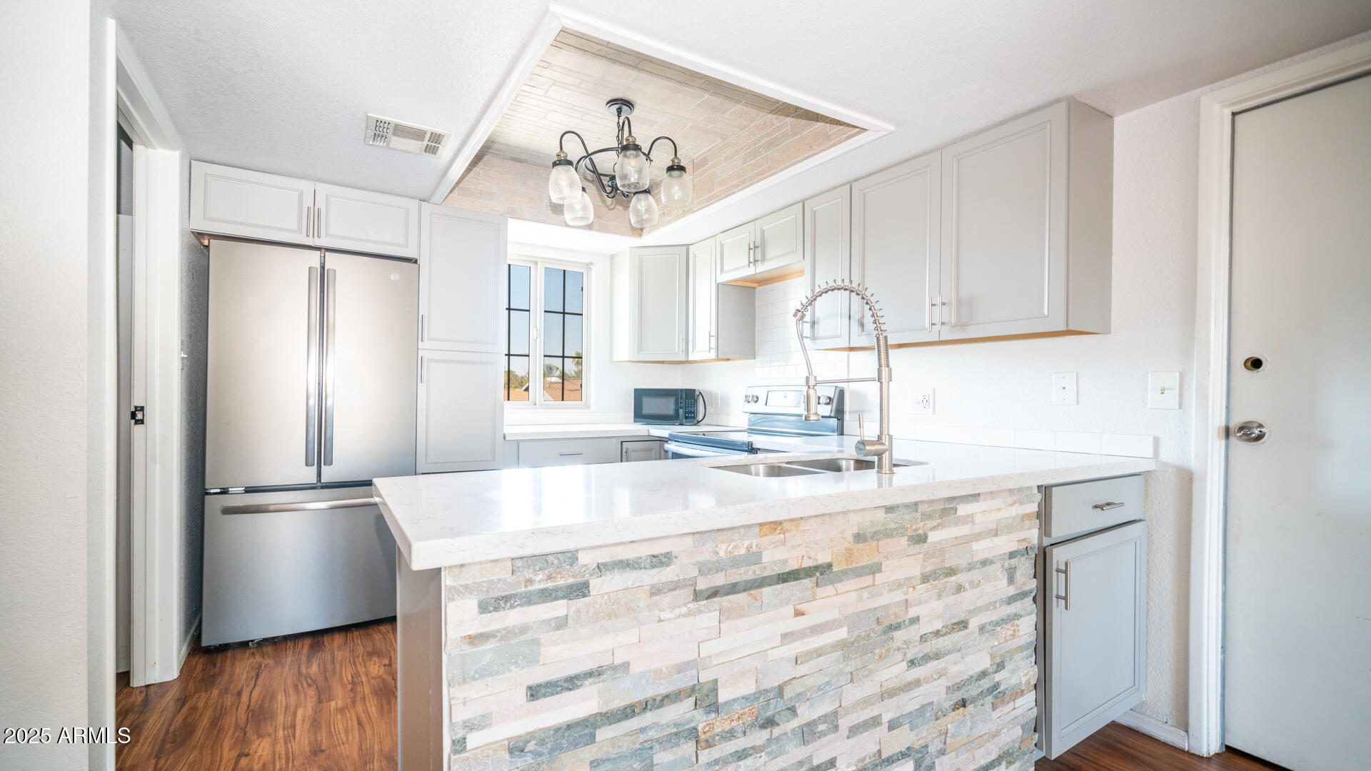 a large kitchen with granite countertop a refrigerator and a sink