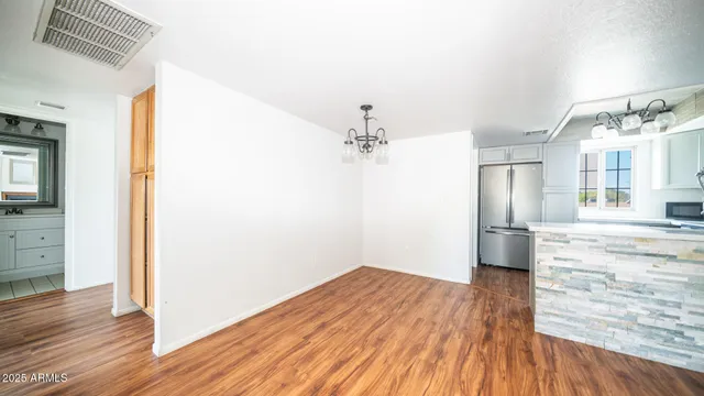 a view of a kitchen with wooden floor and a refrigerator