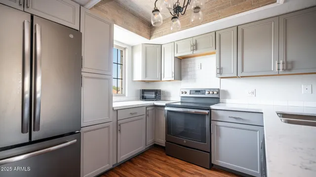 a kitchen with stainless steel appliances granite countertop a refrigerator sink and cabinets