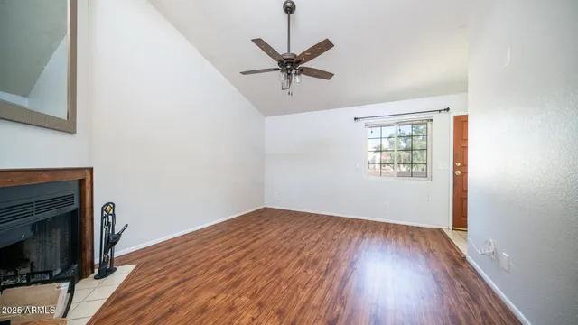 a view of a livingroom with wooden floor and a ceiling fan