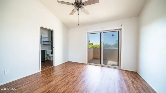 an empty room with wooden floor cabinet and windows