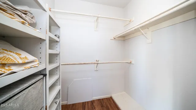 a view of walk in closet with clothes and shoes