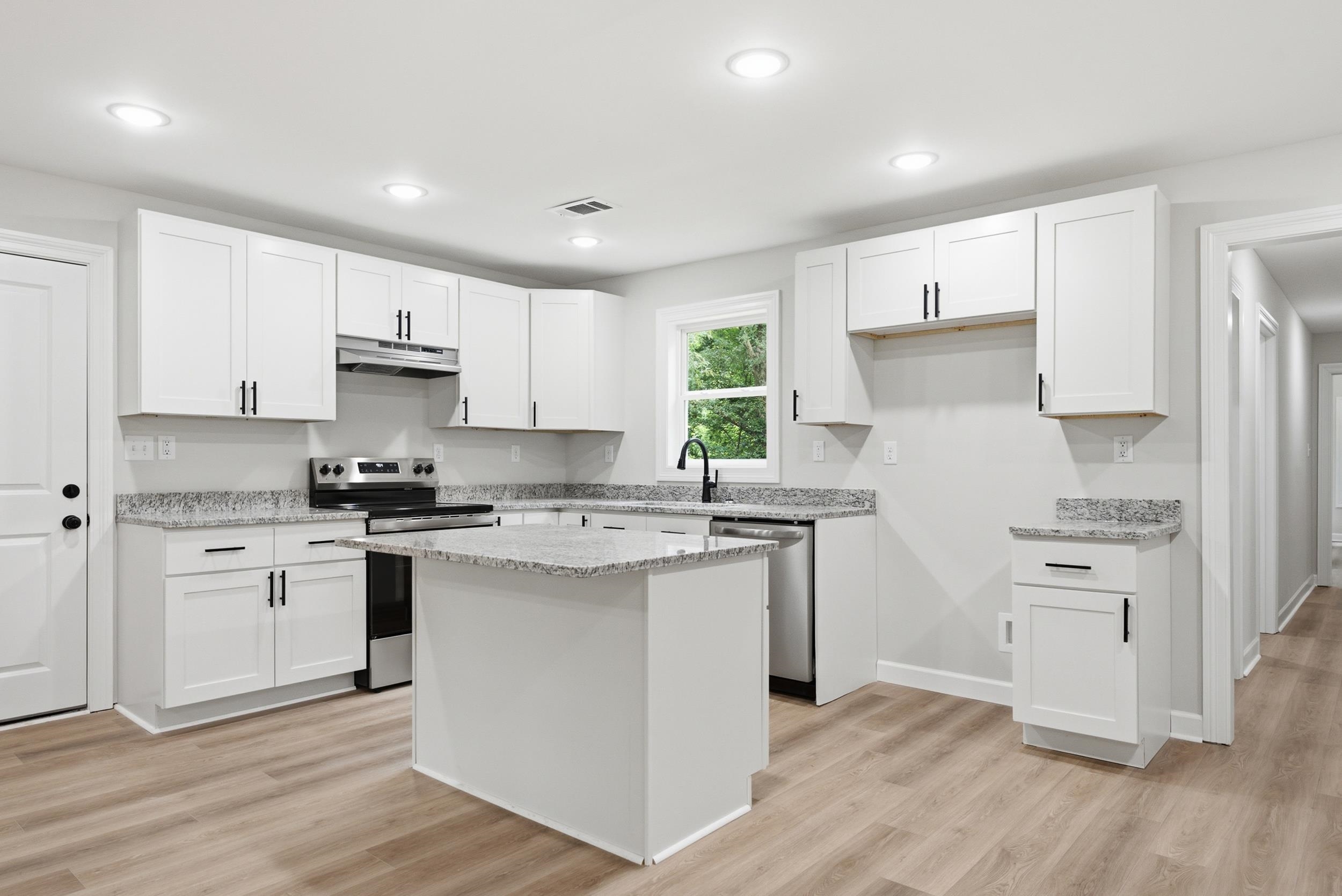 4683 Belmont Road Hernando, MS 38632 - Photo 6 of 21 Kitchen featuring an island, white shaker cabinetry, speckled countertops, stainless steel appliances, and wood-finish flooring