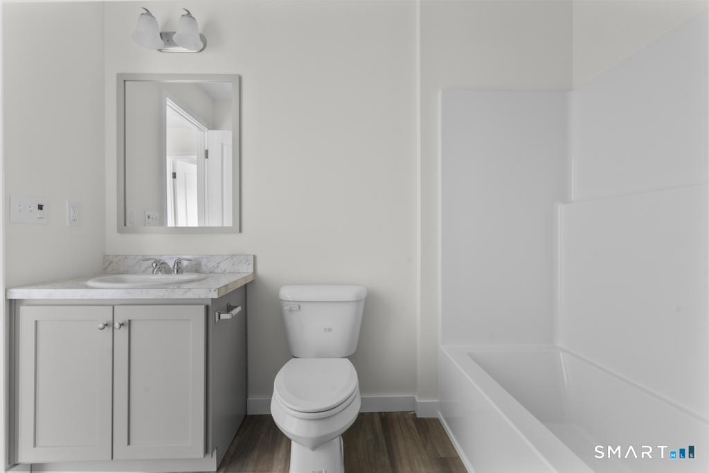 55 Sugar Street, Unit 14 Newtown, CT 06470 - Photo 11 of 18 a bathroom with a toilet a sink and mirror